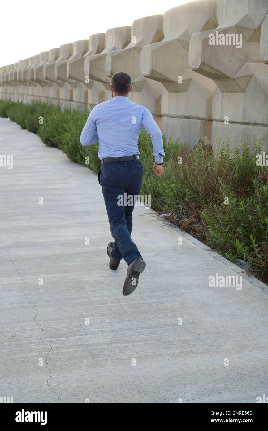 Vista posteriore di un uomo che corre all'aperto Foto Stock