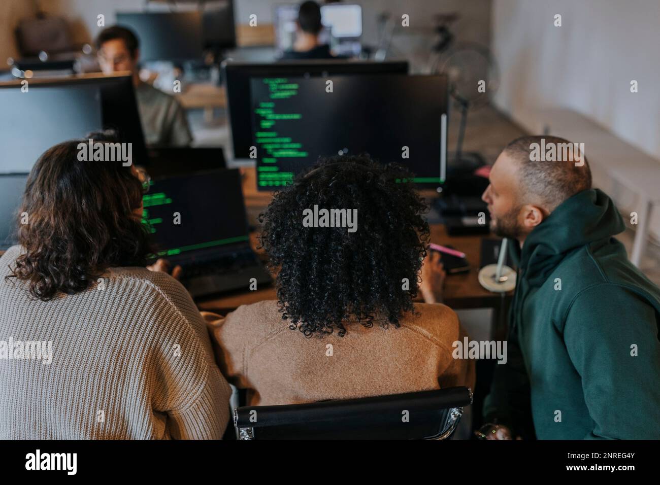 Hacker multirazziali di sesso femminile e maschile che codificano sul computer mentre lavorano sul luogo di lavoro creativo Foto Stock