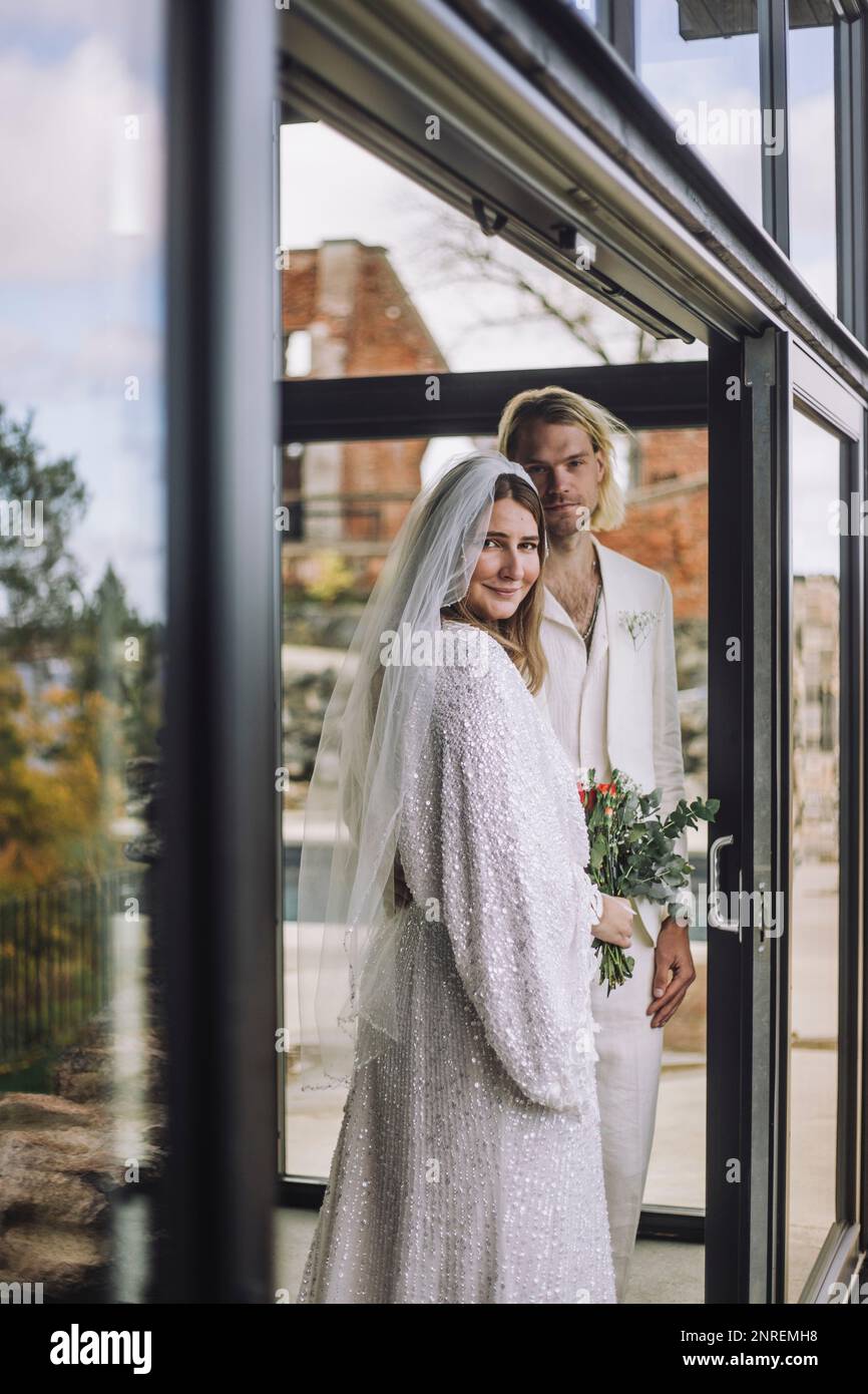 Ritratto di coppia in piedi alla porta della sala d'ingresso durante il matrimonio Foto Stock