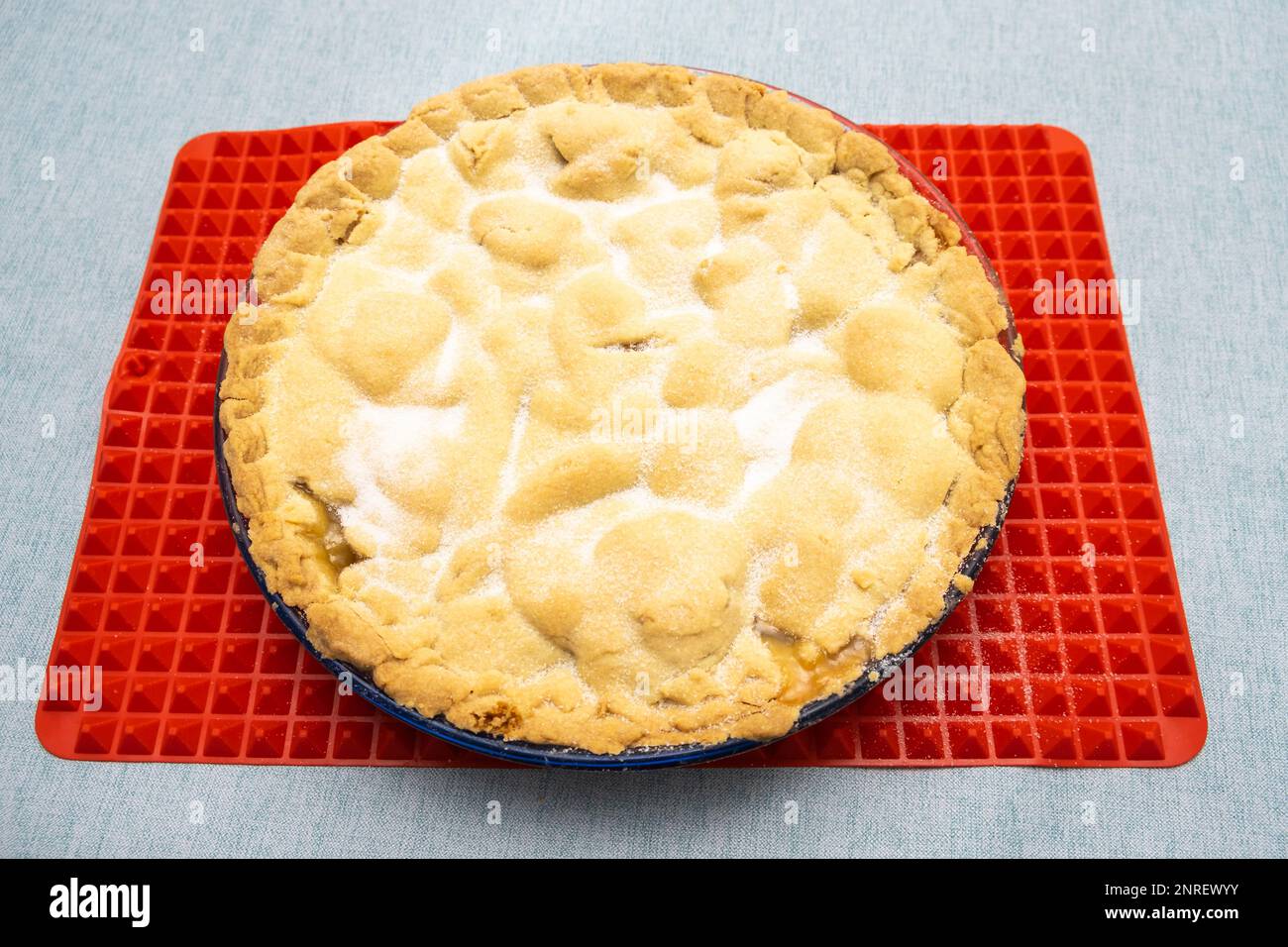Torta di mele fatta in casa appena fuori dal forno su un tappetino termoresistente in silicone. Foto Stock