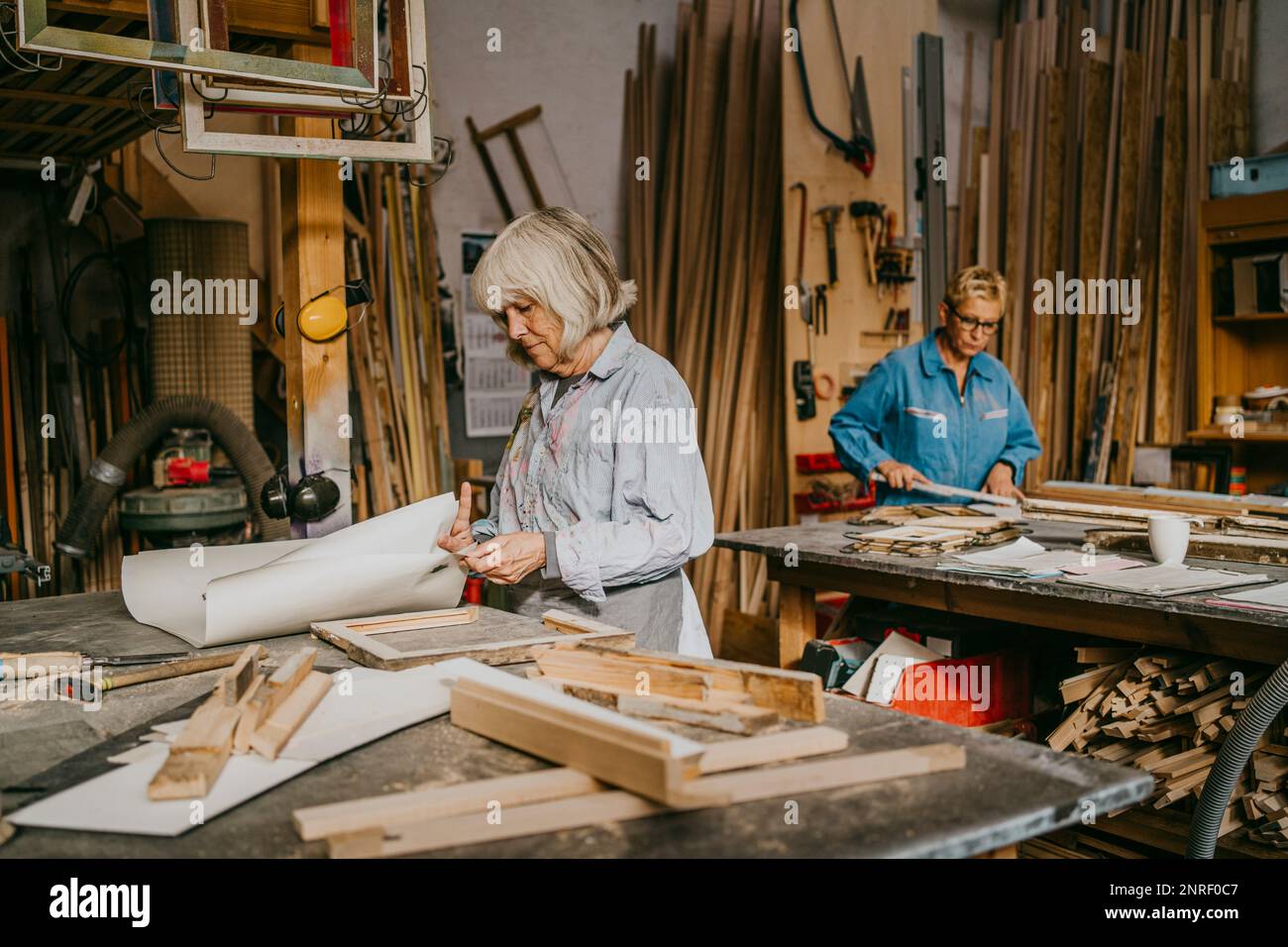 Artigiani senior che lavorano insieme in officina Foto Stock