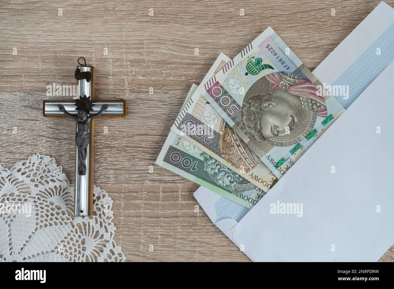 Visita Pastorale o Kolęda, tradizione cattolica dopo Natale in Polonia. Croce e busta con denaro polacco per sacerdote. Koleda donazione per la chiesa. Foto Stock