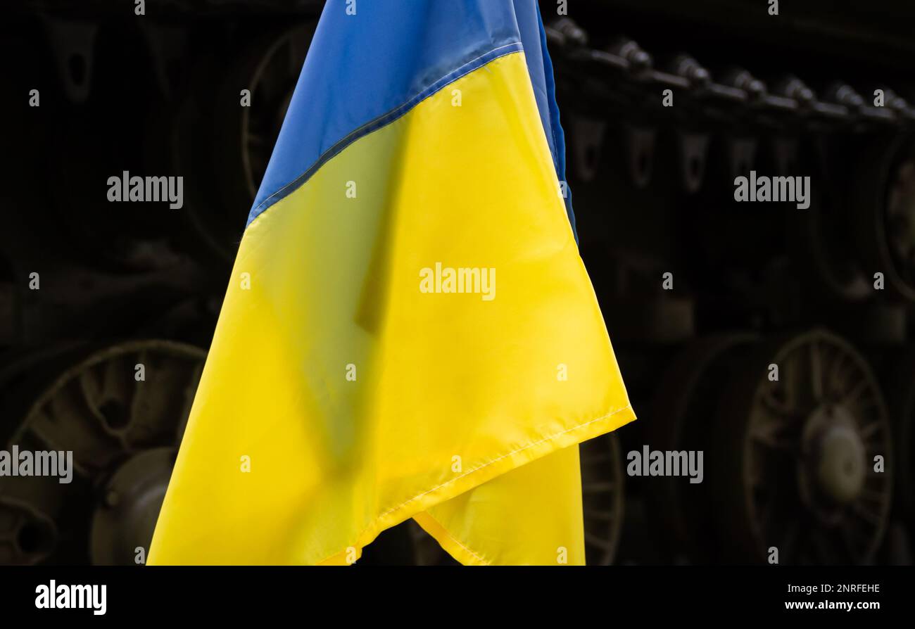 Bandiera nazionale dell'Ucraina, serbatoio militare di battaglia dell'esercito. Manifestazione di protesta contro l'invasione e la guerra della Russia. Bandiera Ucraina, dimostrazione anti-guerra. Foto Stock