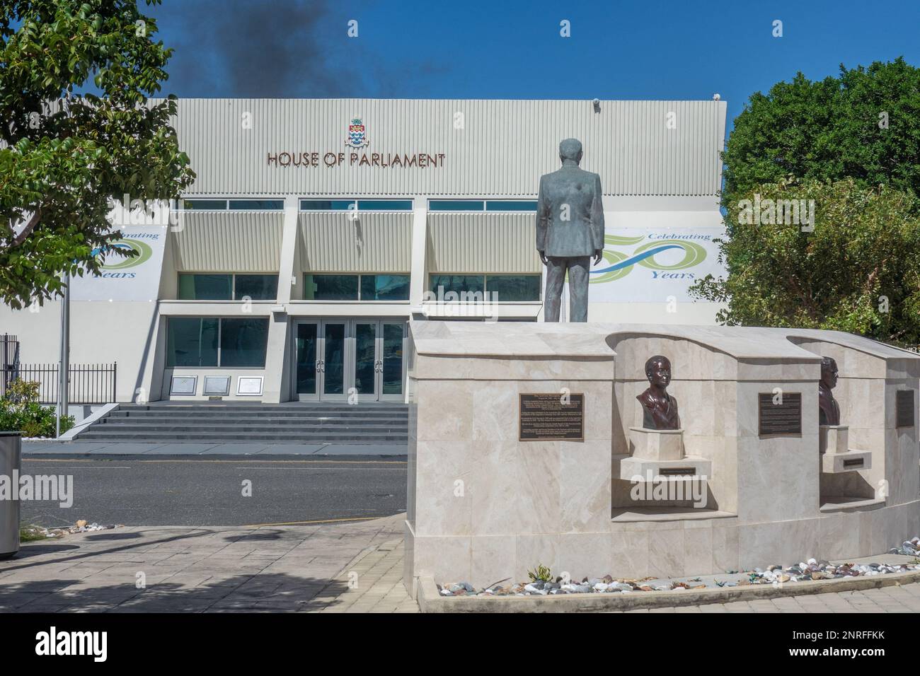 Caraibi, Isole Cayman, Grand Cayman, George Town, edificio del Parlamento da Piazza degli Eroi con statue Foto Stock