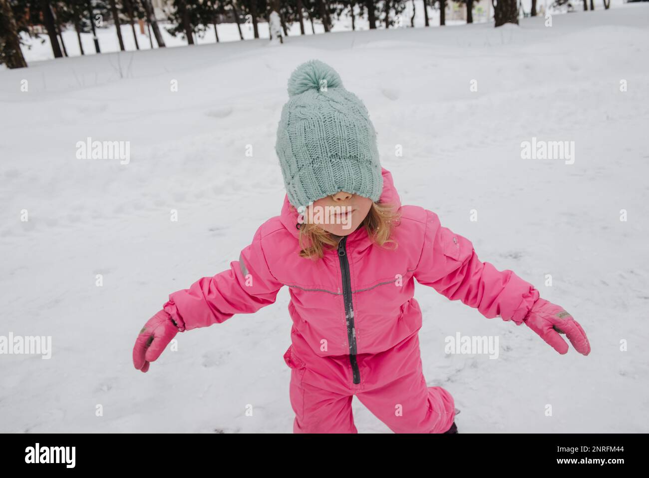 una ragazza in una tuta rosa sta giocando all'aperto Foto Stock