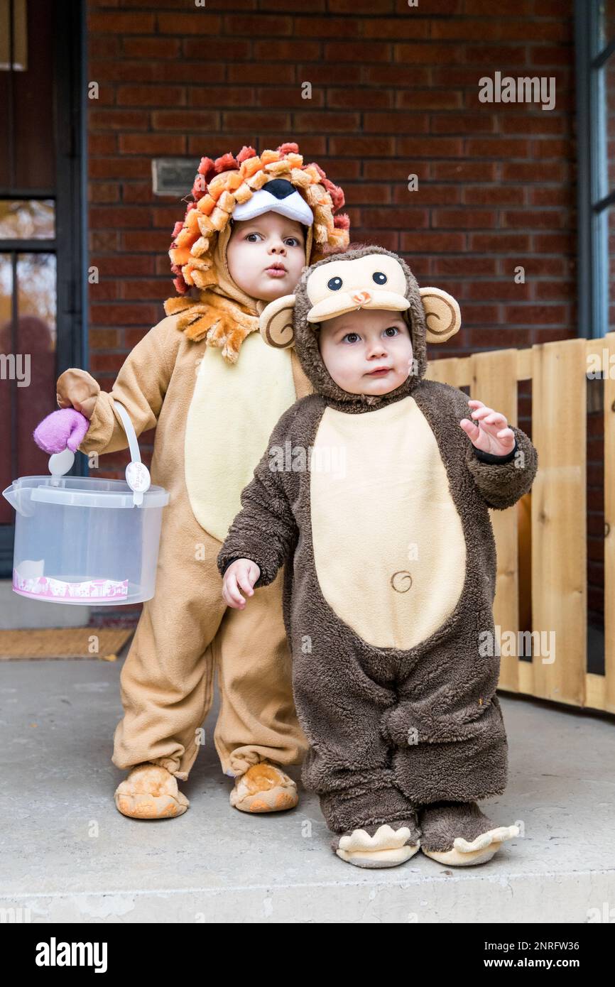 Simpatici toddlers che indossano costumi sul portico anteriore Foto Stock