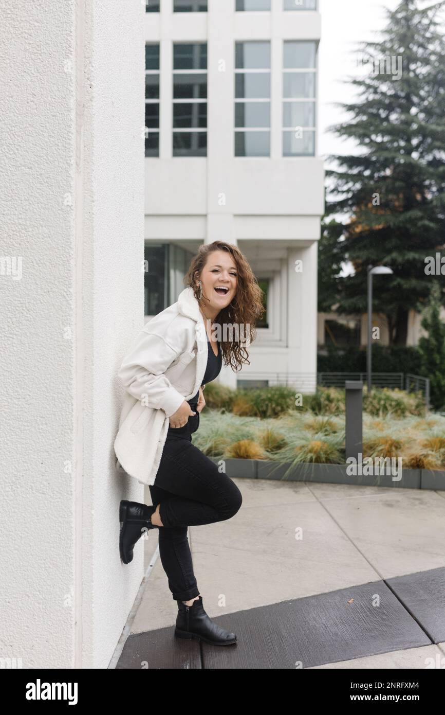 Donna cresciuta alla moda con capelli lunghi che guardano la fotocamera ridere Foto Stock