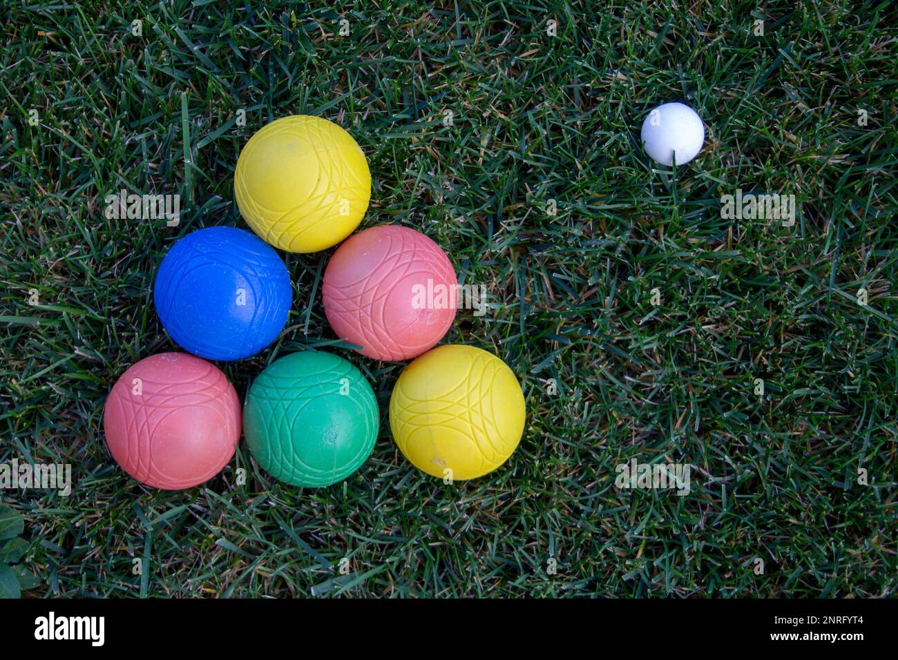 Immagine di una piramide di ciotole colorate in un campo verde con una palla. Foto Stock