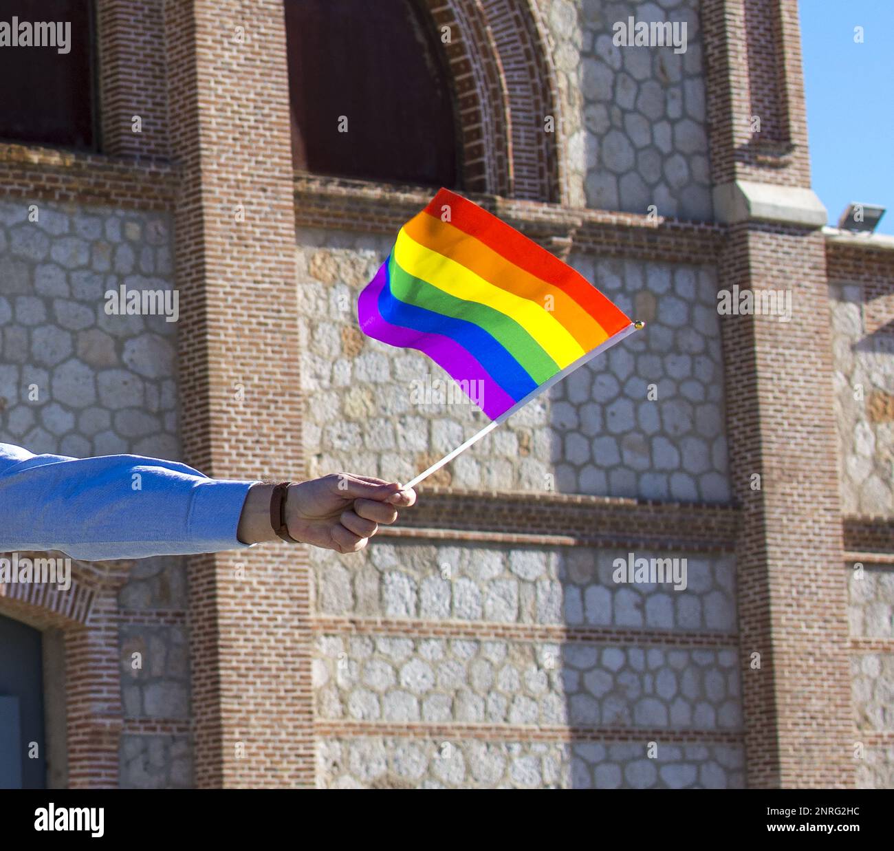 Un uomo che detiene una bandiera arcobaleno Foto Stock