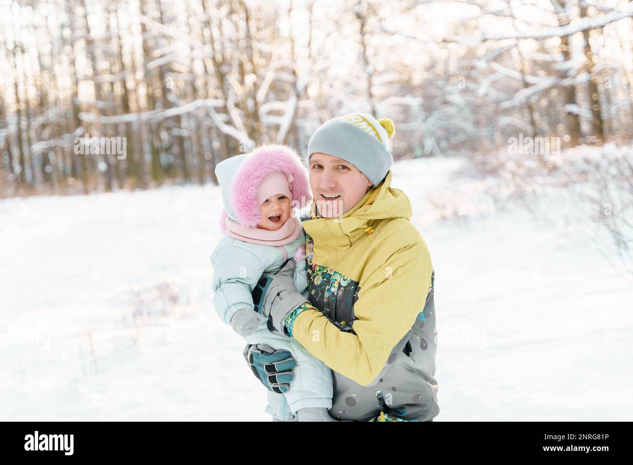 Un uomo di 35-40 anni ha una figlia di un anno in inverno Foto Stock