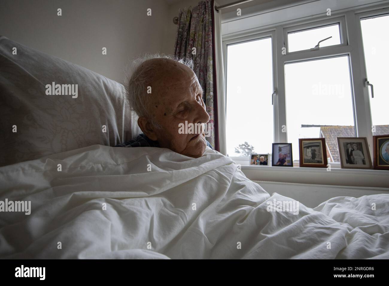 L'uomo anziano di fine anni '80 snoozza nel suo letto di casa di cura, Inghilterra, Regno Unito Foto Stock