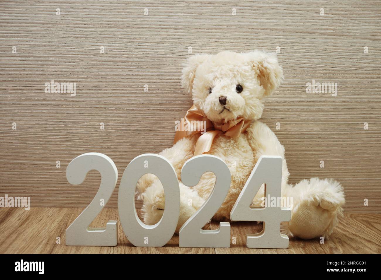 Felice anno nuovo 2024 sfondo festivo con orsacchiotto decorazione su sfondo in legno Foto Stock