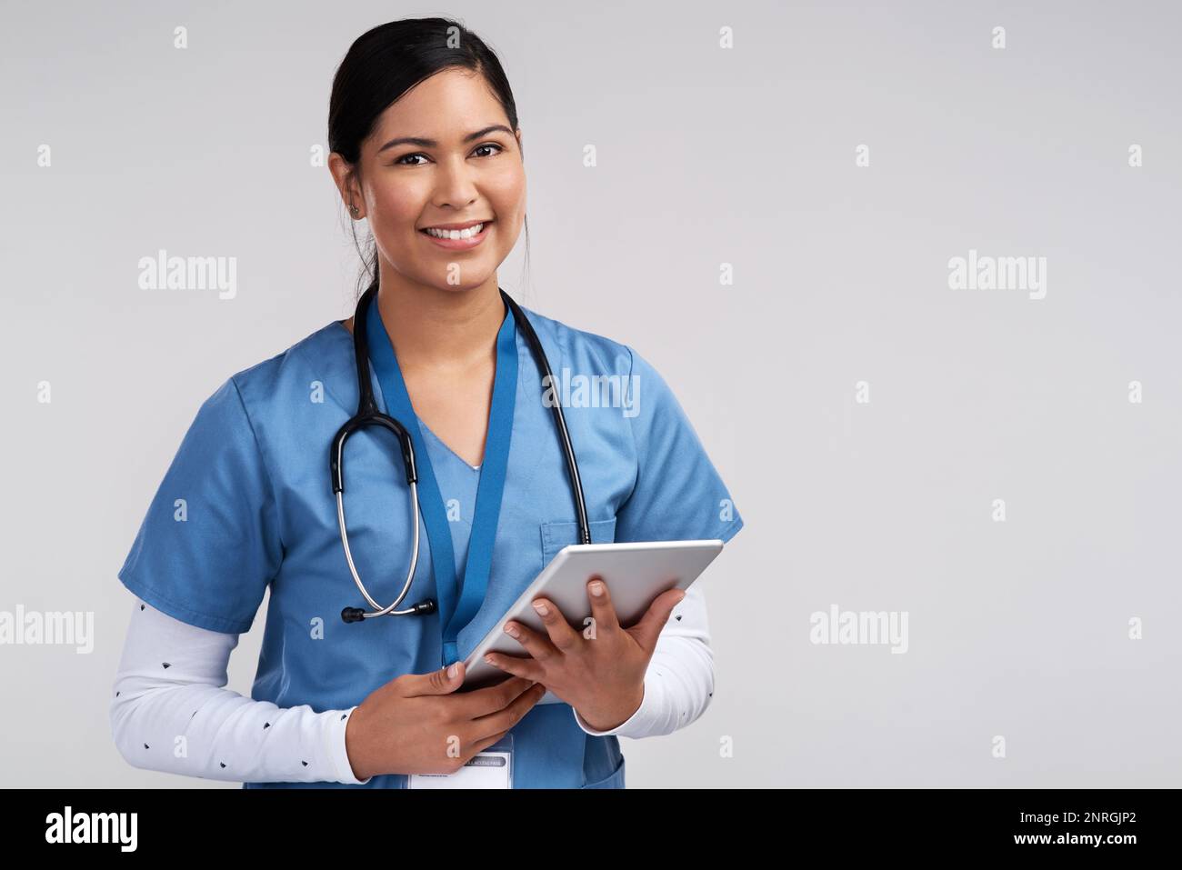 Stupidi i medici che disprezzano le conoscenze acquisite dagli antichi. Ritratto di un giovane medico utilizzando una compressa e indossando uno stetoscopio contro un Foto Stock