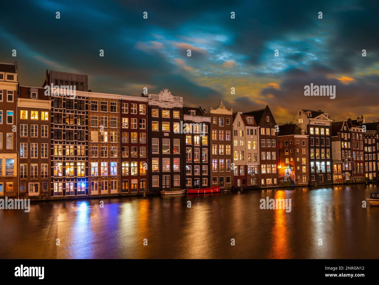 Case tipiche sul Damrak di notte, ad Amsterdam, Paesi Bassi Foto Stock