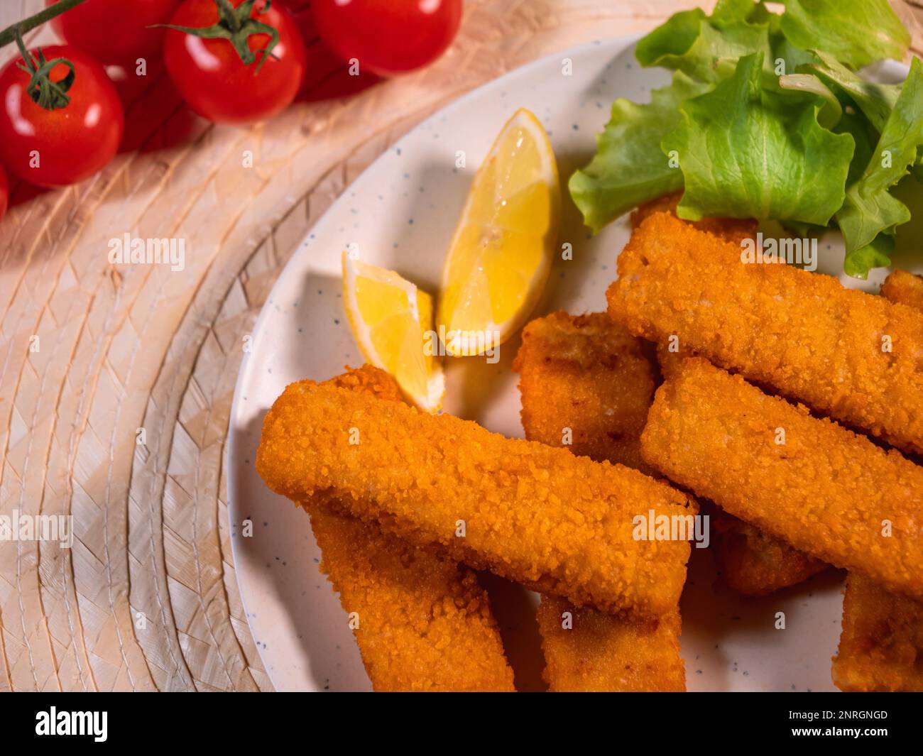 bastoncini di pesce, gustosi frutti di mare, croccanti filetti di pesce fritti serviti con insalata e pomodori. Fast food. vista dall'alto. Foto Stock