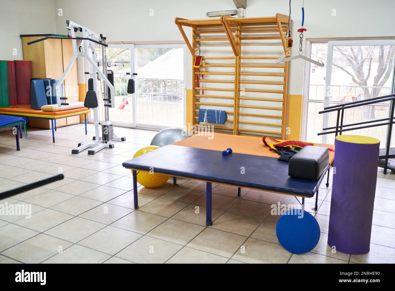 Interno del centro di riabilitazione con varie attrezzature sportive e letto in camera Foto Stock