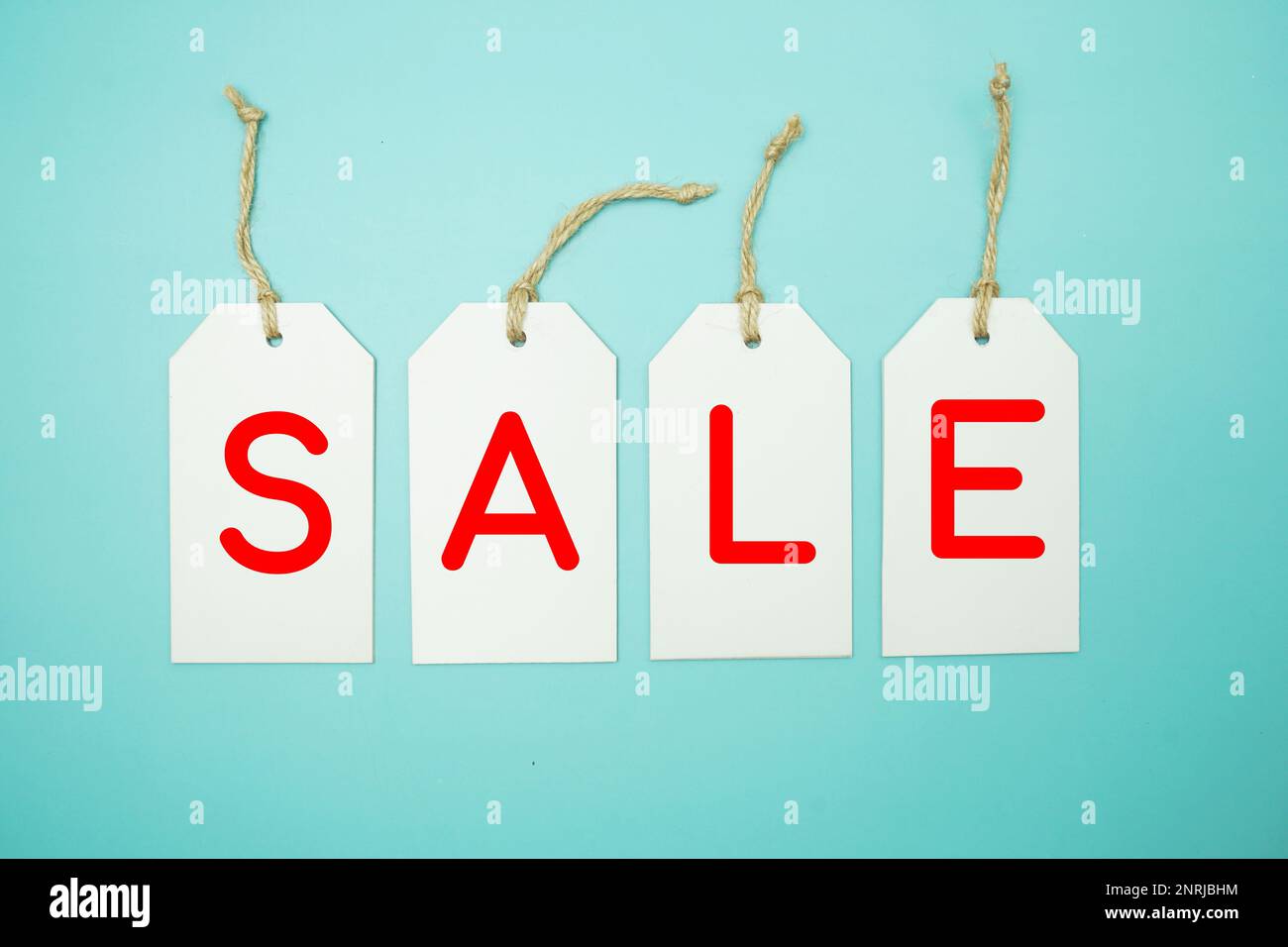 Etichette bianche con LETTERE dell'alfabeto DI VENDITA su sfondo blu Foto Stock