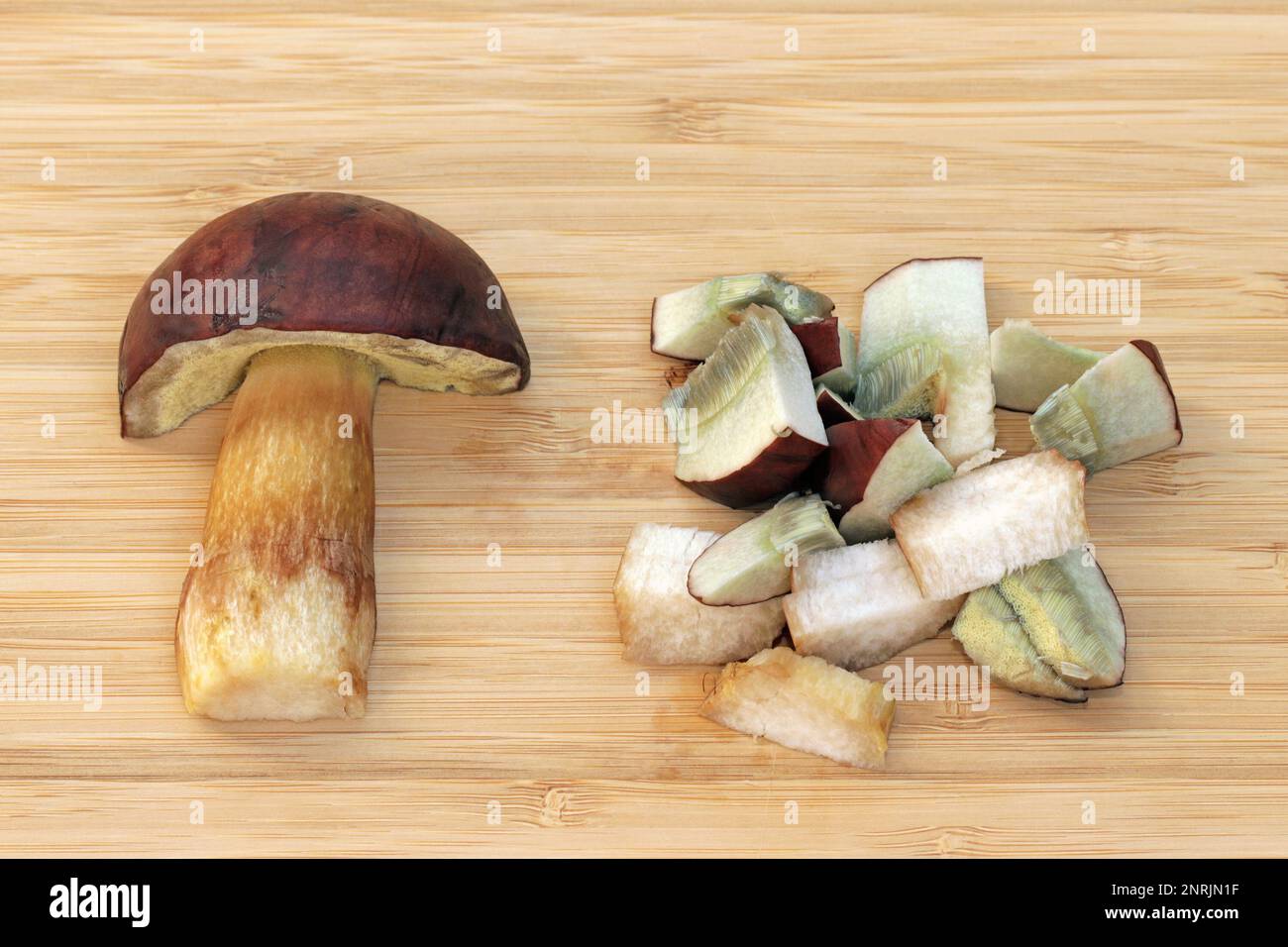 Metà e fette di funghi commestibili Imleria badia, comunemente conosciuta come baie bolete. I pori e la carne macchiano da blu opaco a grigio-bluastro quando sono ammaccati o tagliati. Frutta Foto Stock