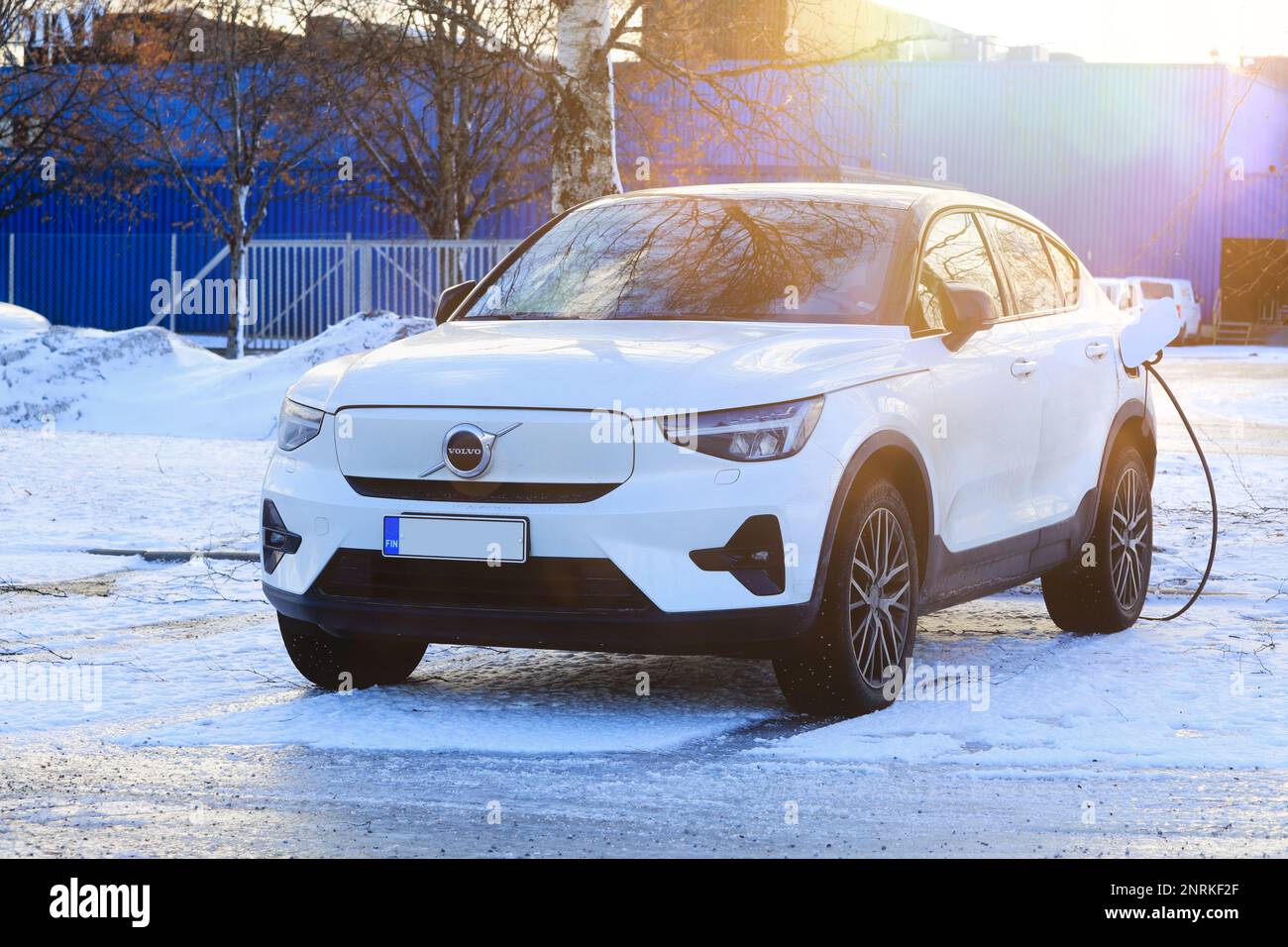 Volvo XC40 bianco ricarica la batteria dell'auto elettrica in un cantiere in un giorno d'inverno. Salo, Finlandia. Febbraio 10, 2023. Foto Stock