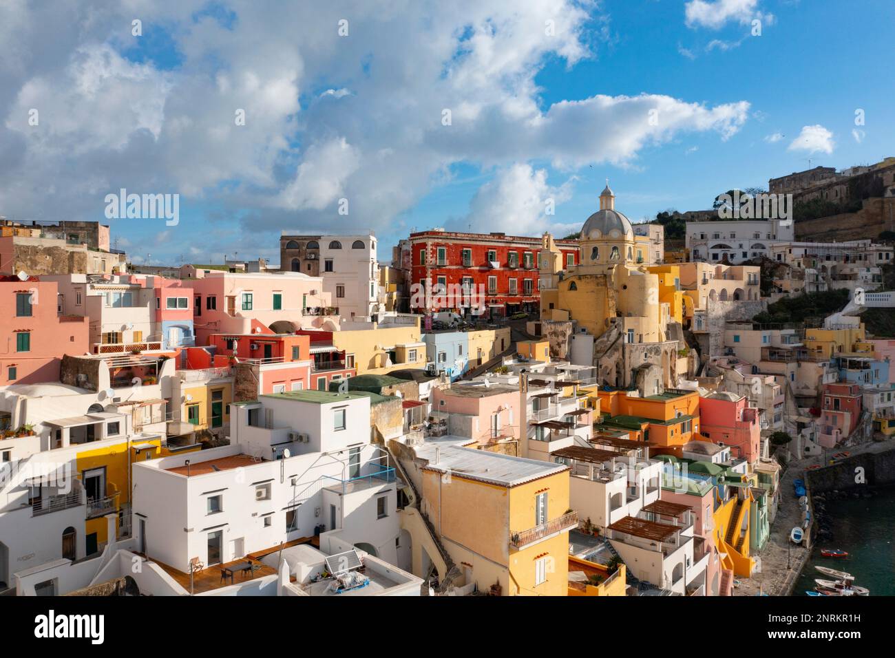 Veduta del porto di Corricella con un sacco di case colorate in una giornata di sole in Isola di Procida, Italia. Foto Stock