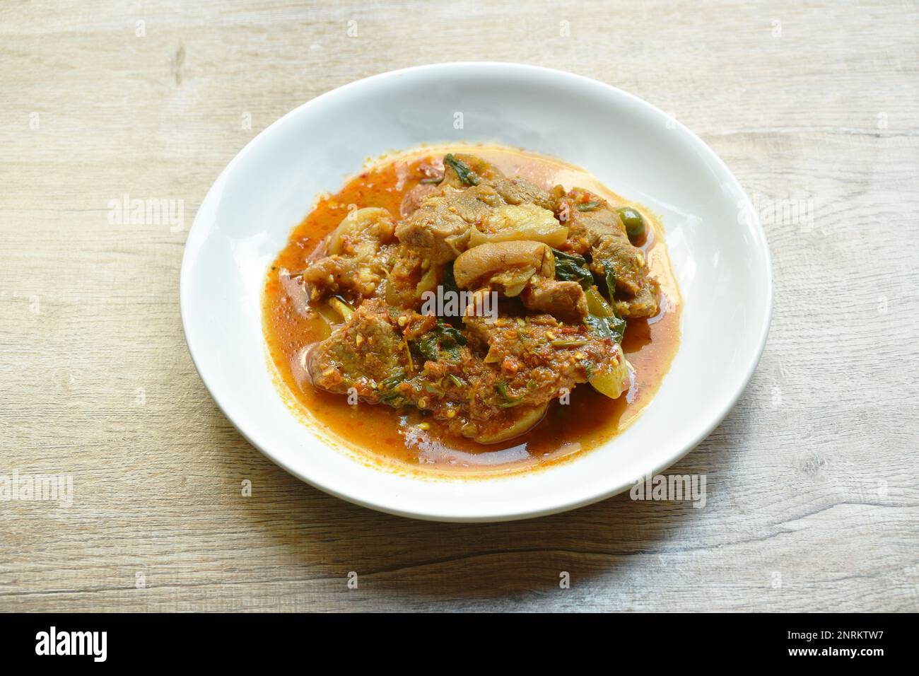 aggiungere una fetta di maiale piccante e fritta con curry di melanzane piastra Foto Stock