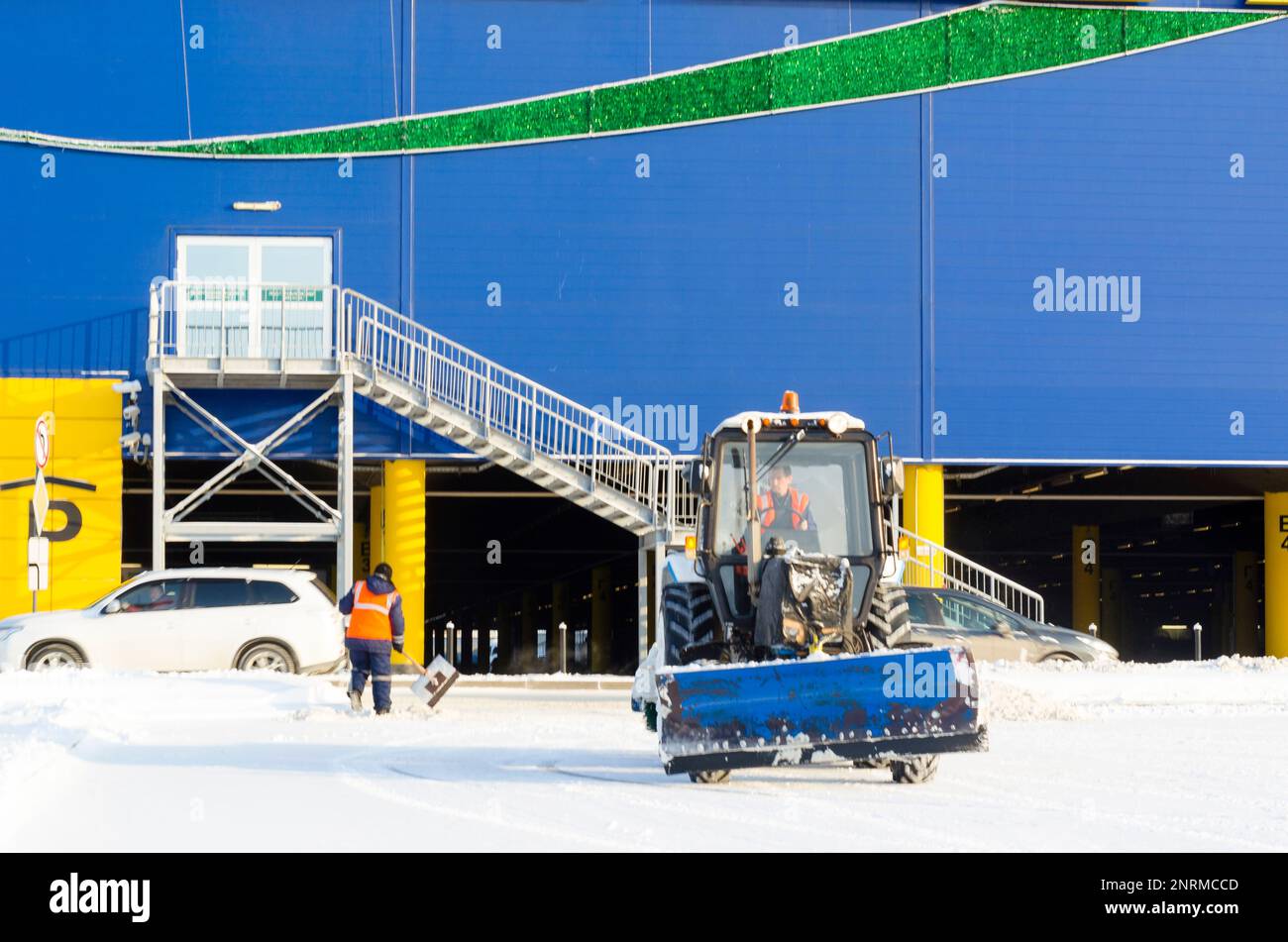 L'iscrizione sul negozio 'IKEA', con decorazioni natalizie accanto al trattore e neve più pulita il parcheggio in inverno dalla Russia Foto Stock