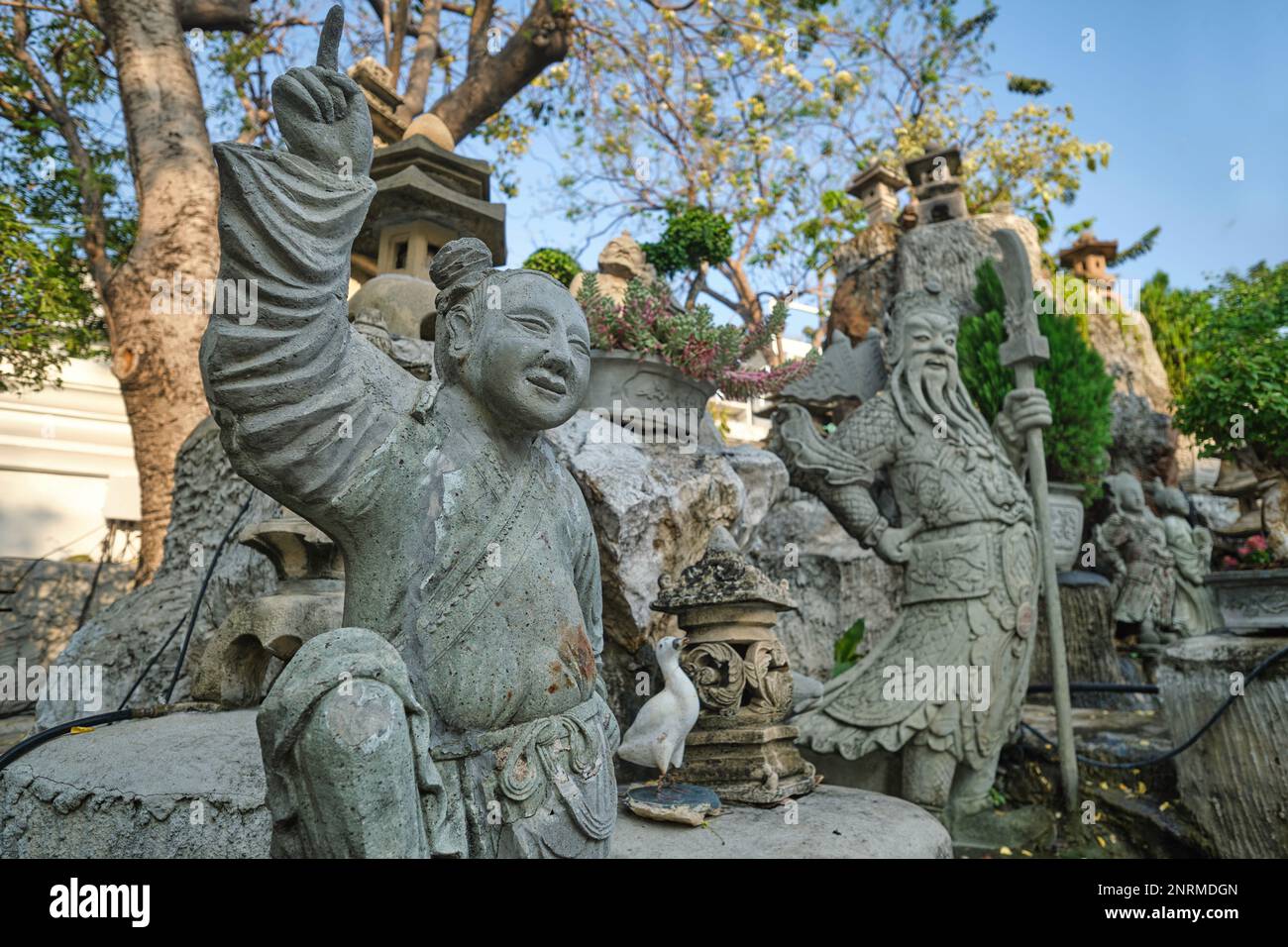 Statue cinesi di pietra portate dalla Cina come zavorra sulle navi che consegnano riso in Cina, in un piccolo giardino a Wat Suthat (tempio) Bangkok, Thailandia Foto Stock