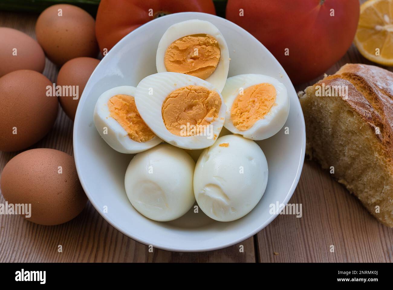 uova di pollo bollite molto fresche, con un tuorlo rotondo giallo o arancione e un bianco ben formato. uovo su un tavolo di legno Foto Stock