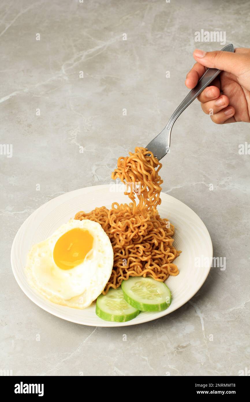 Mangiare Noodle fritto Indomie Goreng, prendere Noodle con forchetta. Copia spazio per testo Foto Stock