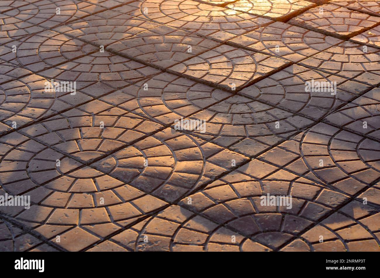 Le lastre di pavimentazione si trovano inesattamente sotto le onde del sole su una strada nella città della Russia Foto Stock