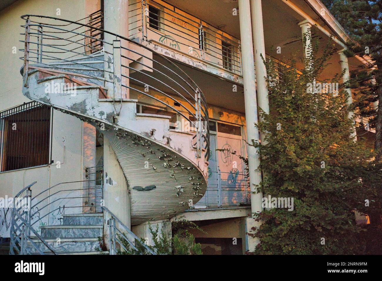 Luogo abbandonato edificio residenziale: Scala a chiocciola su cui la vernice è scheggiato al crepuscolo sera. Foto Stock
