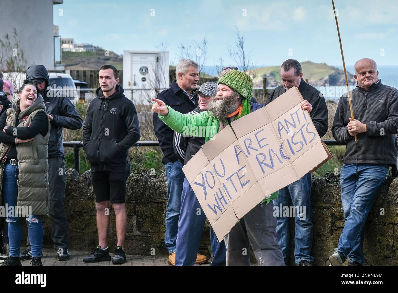Un manifestante arrabbiato che tiene un cartellone di cartone e urla durante una manifestazione organizzata dal gruppo di destra Reform UK contro i richiedenti asilo pl Foto Stock
