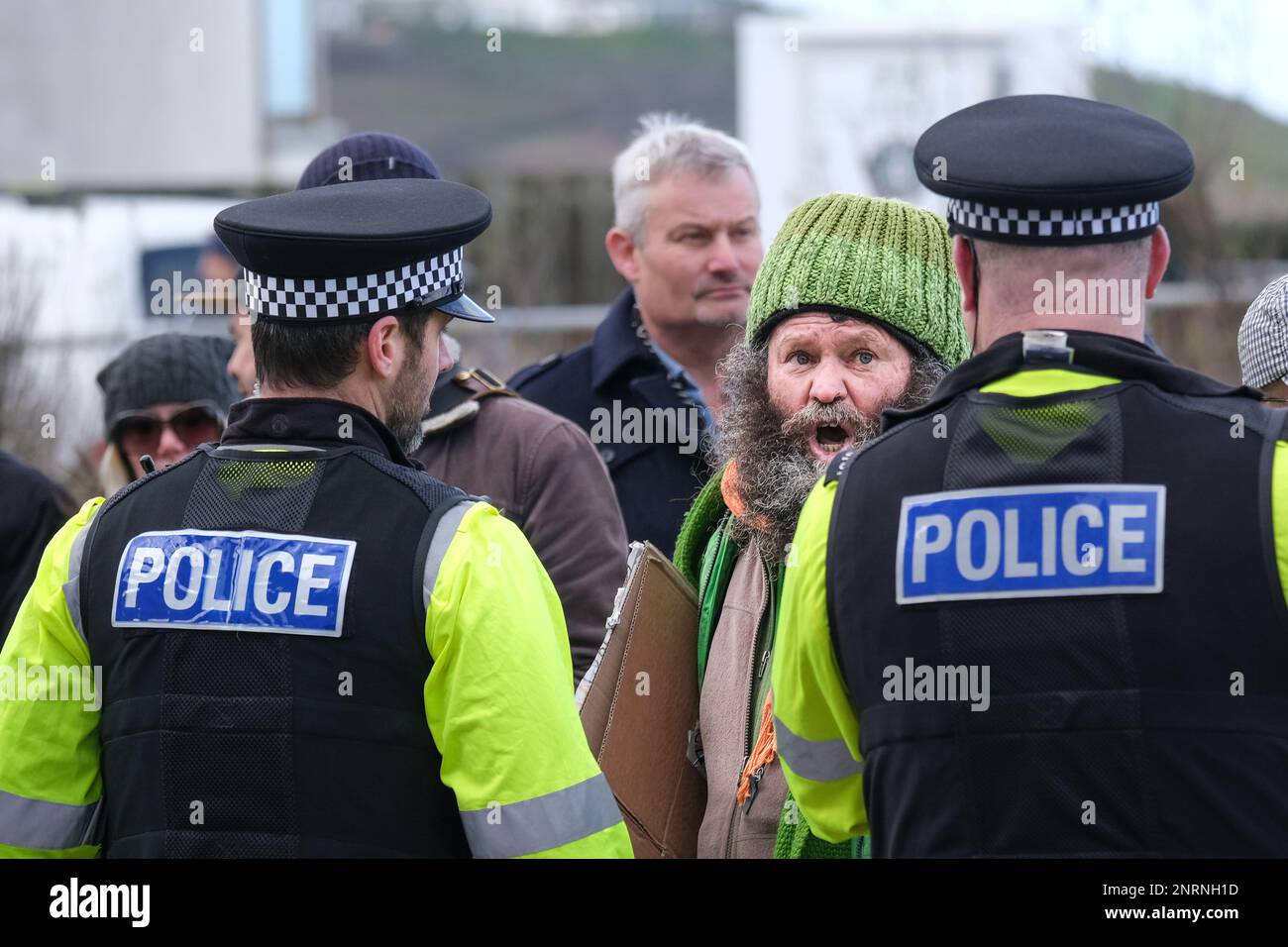 Gli ufficiali di polizia si confrontano con un protesista arrabbiato che urla durante una manifestazione organizzata dal gruppo di destra Reform UK contro i richiedenti asilo pla Foto Stock