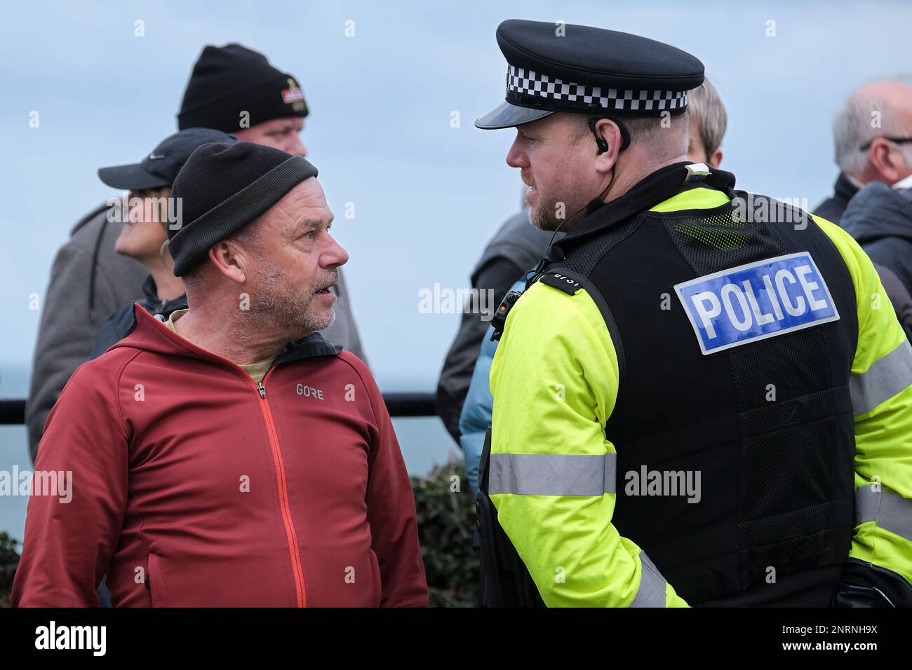 Un ufficiale della polizia del Devon e della Cornovaglia che parla con un manifestante durante una manifestazione organizzata dal gruppo di destra Reform UK contro i richiedenti asilo p Foto Stock