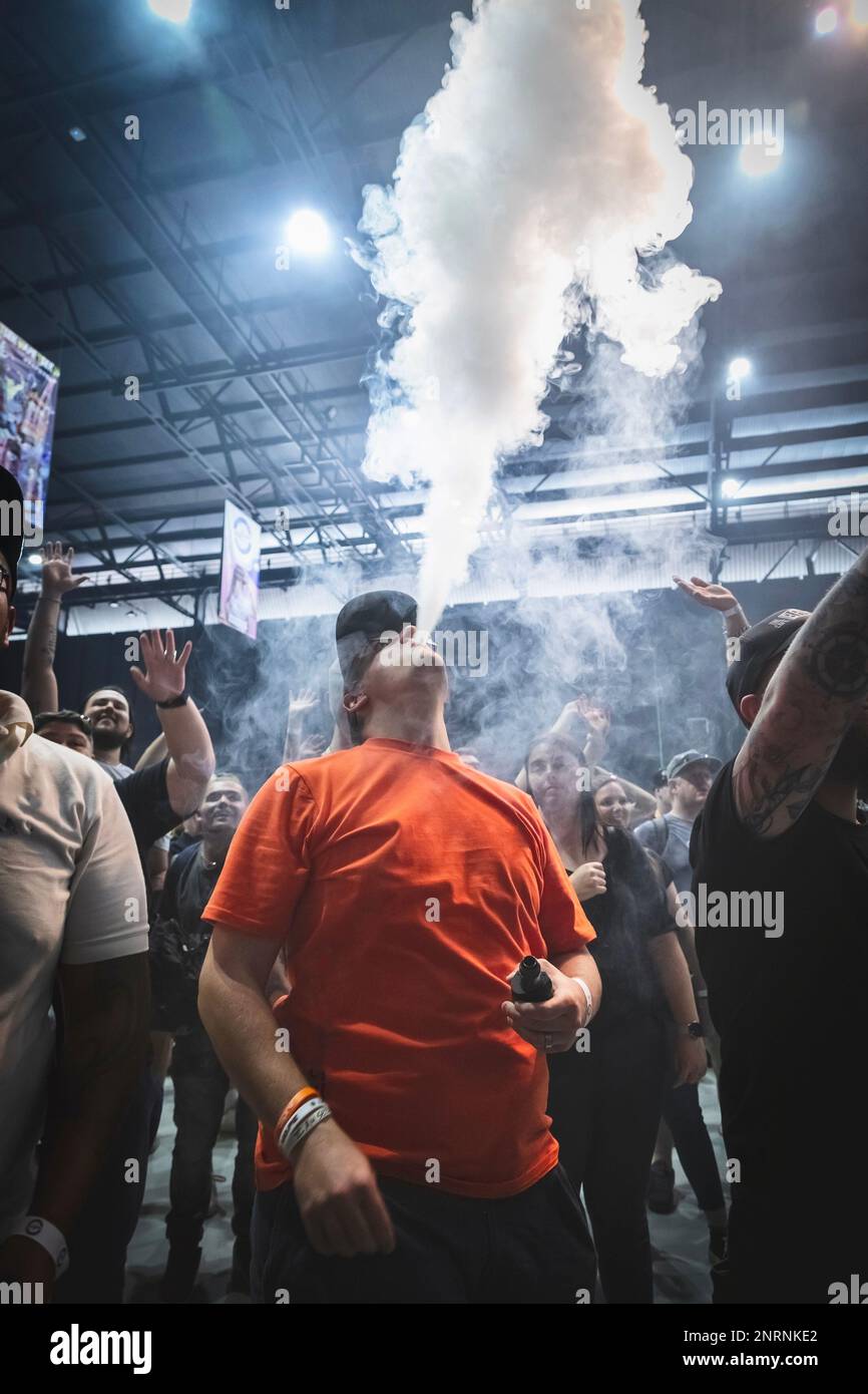 Johannesburg, Sud Africa, 27th novembre - 2022: Il giovane soffia il fumo di vape alla mostra di vaping nella grande sala espositiva. Foto Stock