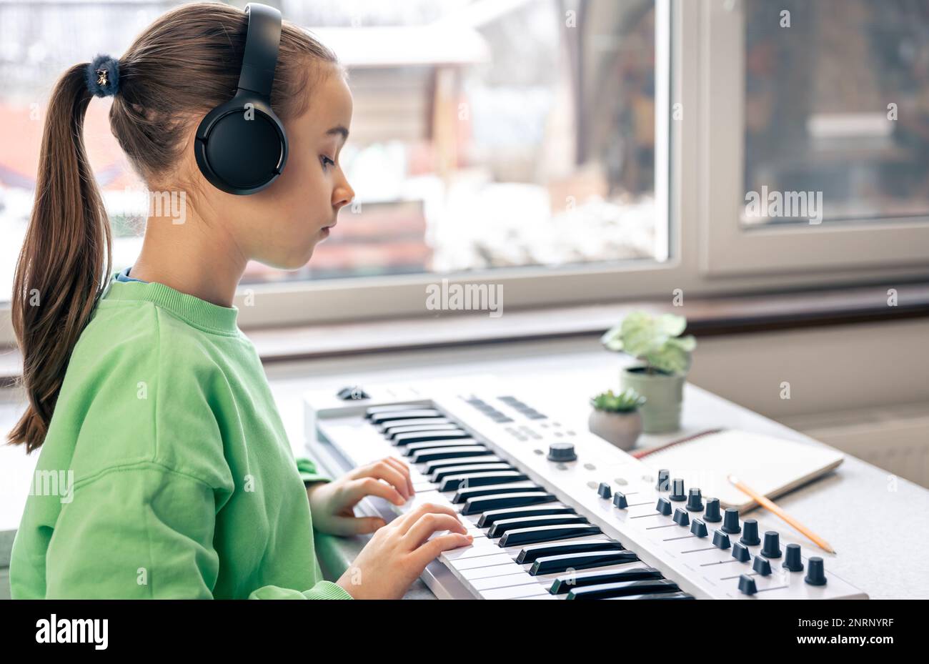 Bambina che impara a suonare il pianoforte a casa, lezione di musica, apprendimento. Foto Stock