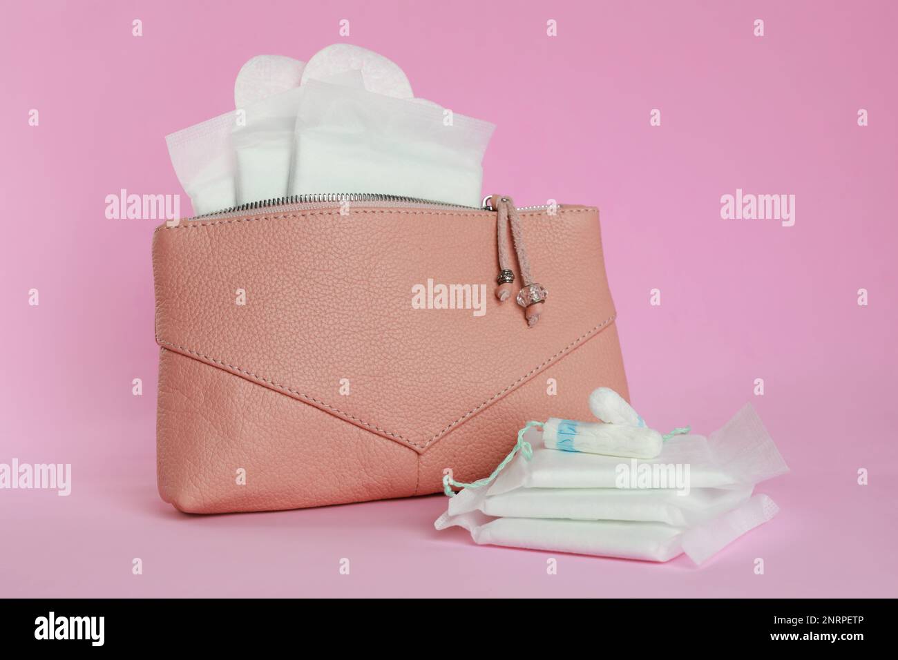 Borsa con tamponi e tamponi mestruali su sfondo rosa Foto Stock