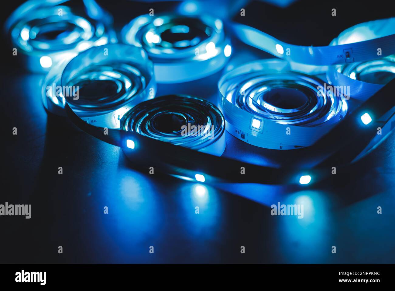 Una pila di luci a LED su strisce luminose flessibili a spirale, di colore blu Foto Stock