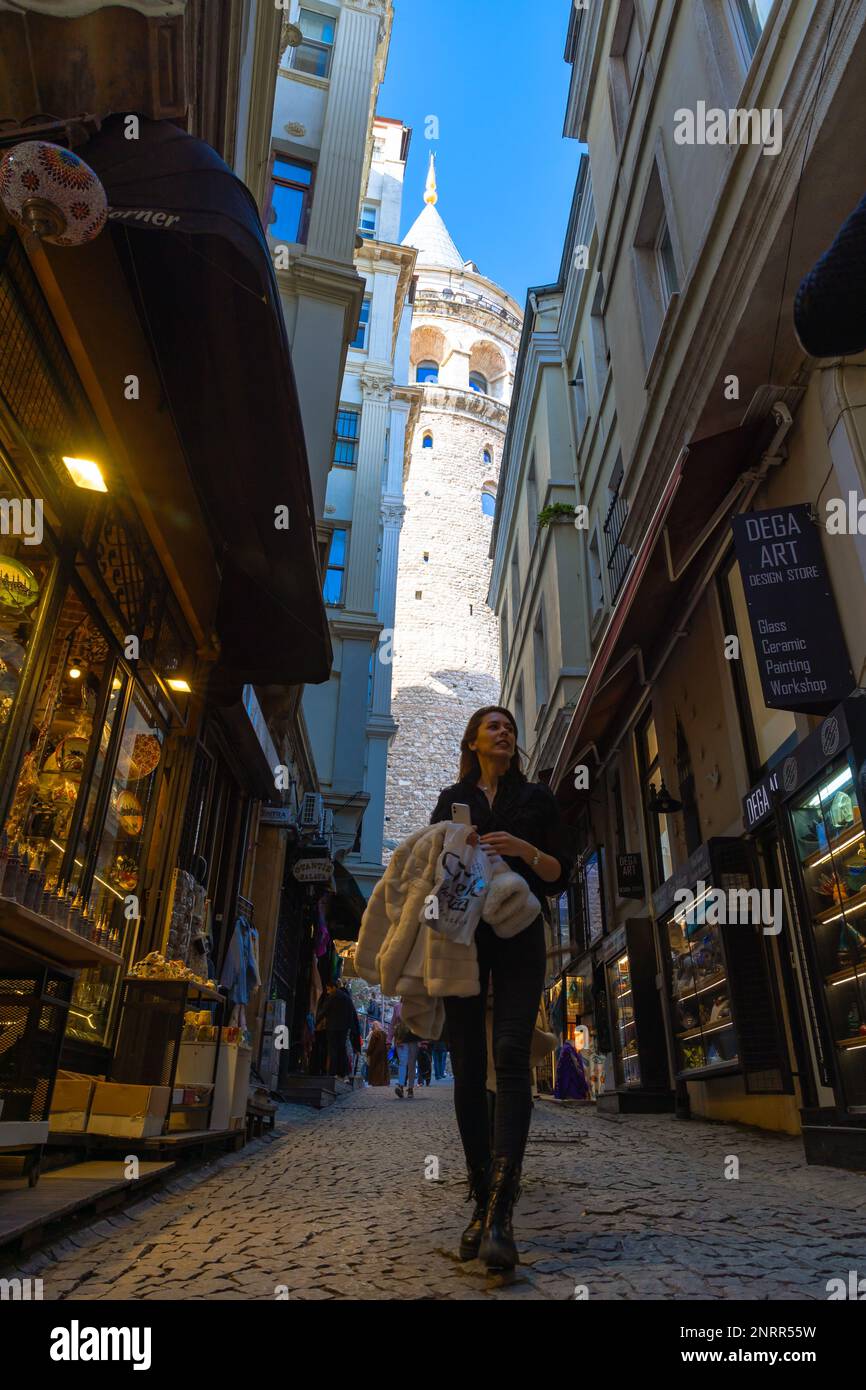 Viaggio a Istanbul foto di sfondo. Donna che cammina per strada e Torre Galata sullo sfondo. Istanbul Turkiye - 1.18.2023 Foto Stock