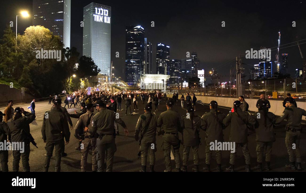 TEL AVIV, ISRAELE - FEBBRAIO 25: I membri della sicurezza israeliana vigilano come manifestanti anti anti anti-governativi marciano e bloccano l'autostrada Ayalon, Una delle principali superstrade di Israele durante una manifestazione contro la nuova coalizione di destra del primo ministro Benjamin Netanyahu e le sue proposte di cambiamenti giudiziari che mirano a indebolire la Corte Suprema del paese il 25 febbraio 2023 a Tel Aviv, Israele. Decine di migliaia di persone si radunano per l'ottava settimana consecutiva in tutto Israele contro l'ampia e controversa riforma del sistema giuridico israeliano Foto Stock