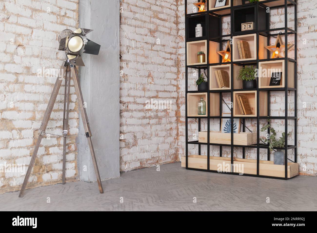 Loft moderno soggiorno interno studio fotografico, lampada sorgente, libreria libreria dietro parete in mattoni vintage naturale. Concetto di spazio business per lavori artistici. così Foto Stock