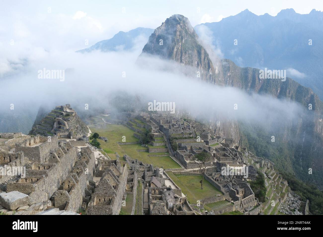 Vista della Città Inca perduta di Machu Picchu sotto il cielo nebbioso vicino Cusco, Perù. Machu Picchu è un santuario storico peruviano. Foto Stock