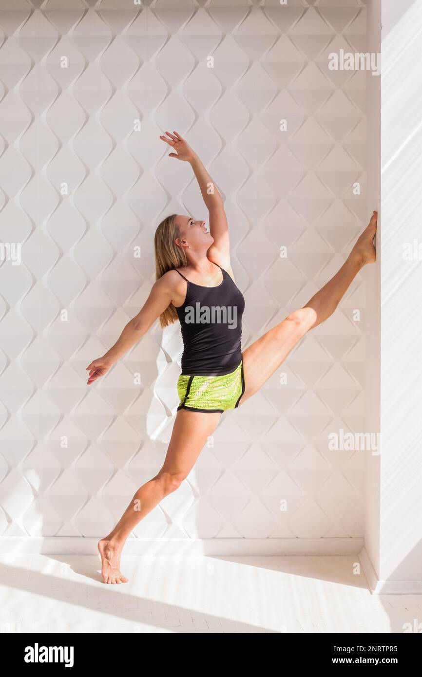 Giovane felice modello di fitness donna atleta fare stretching allenamento vicino al sole luminoso muro. Vita sana bodybuilding concetto di stile di vita immagine, poliziotto Foto Stock