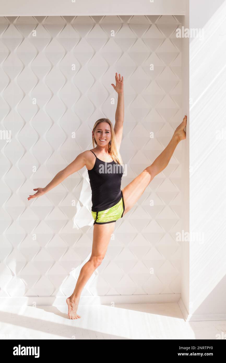 Giovane felice modello di fitness donna atleta fare stretching allenamento vicino al sole luminoso muro. Vita sana bodybuilding concetto di stile di vita immagine, poliziotto Foto Stock