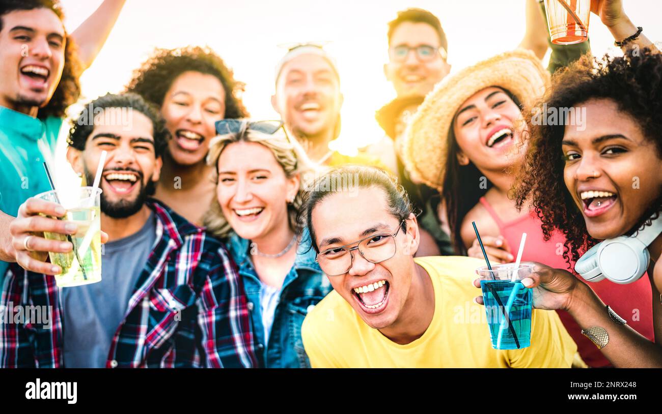 Amici multirazziali che prendono selfie al concerto del tramonto il giorno di vacanza - concetto di stile di vita di festa con i giovani che si divertono insieme durante la pausa di primavera Foto Stock