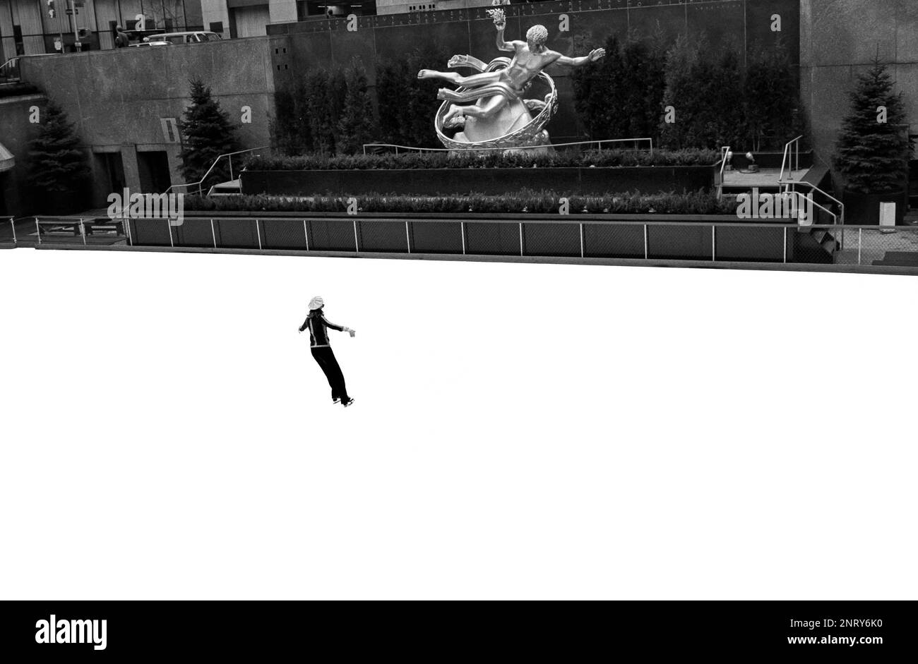 Pattinatore di ghiaccio e la scultura in bronzo dorato del 1934 di Prometheus di Paul Manship presso la pista di pattinaggio su ghiaccio del Rockefeller Center a New York City, NY Foto Stock