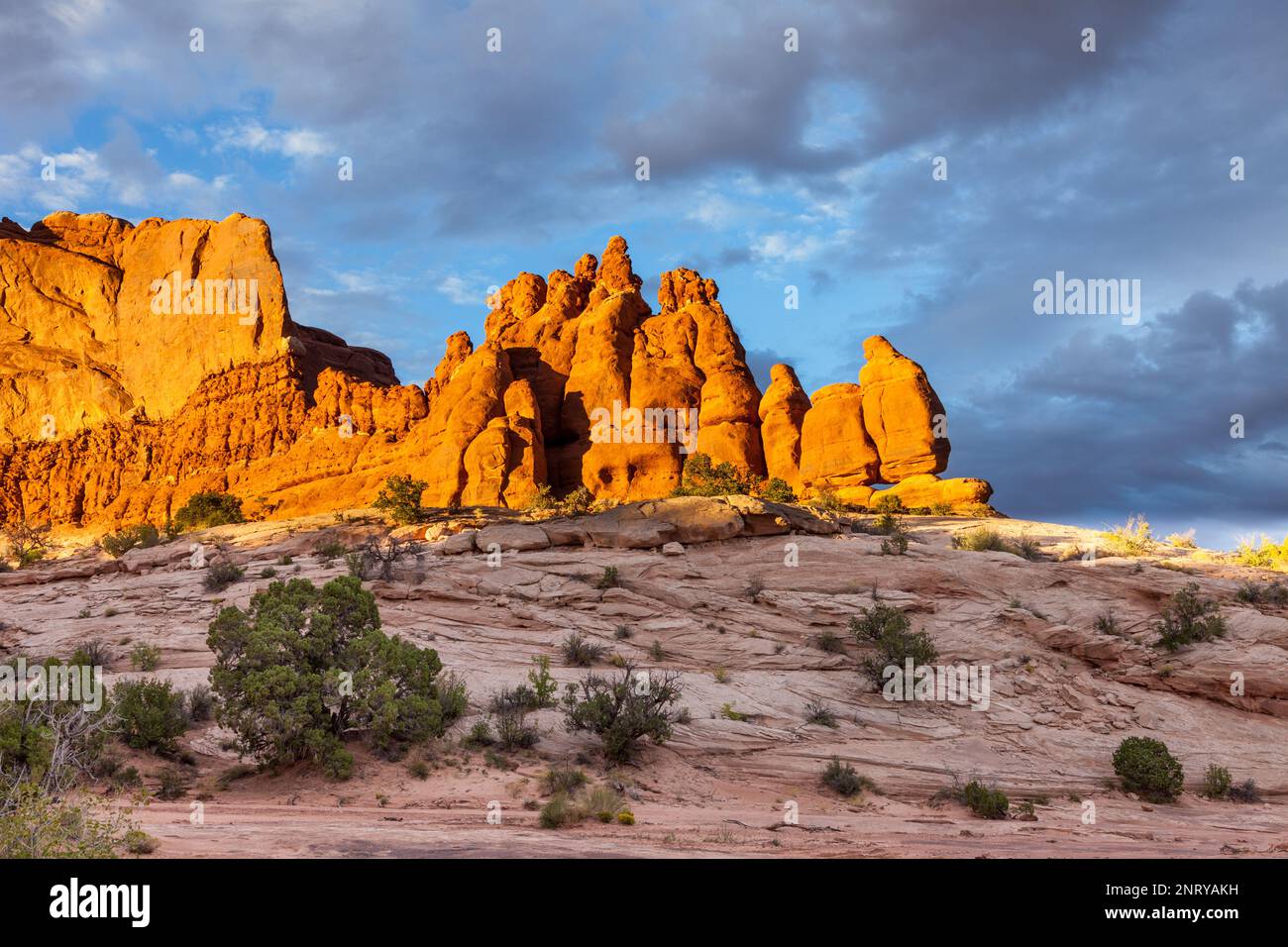 Cielo tempestoso sulle formazioni di arenaria Entrada delle rocce Navajo al tramonto vicino a Moab, Utah. Foto Stock