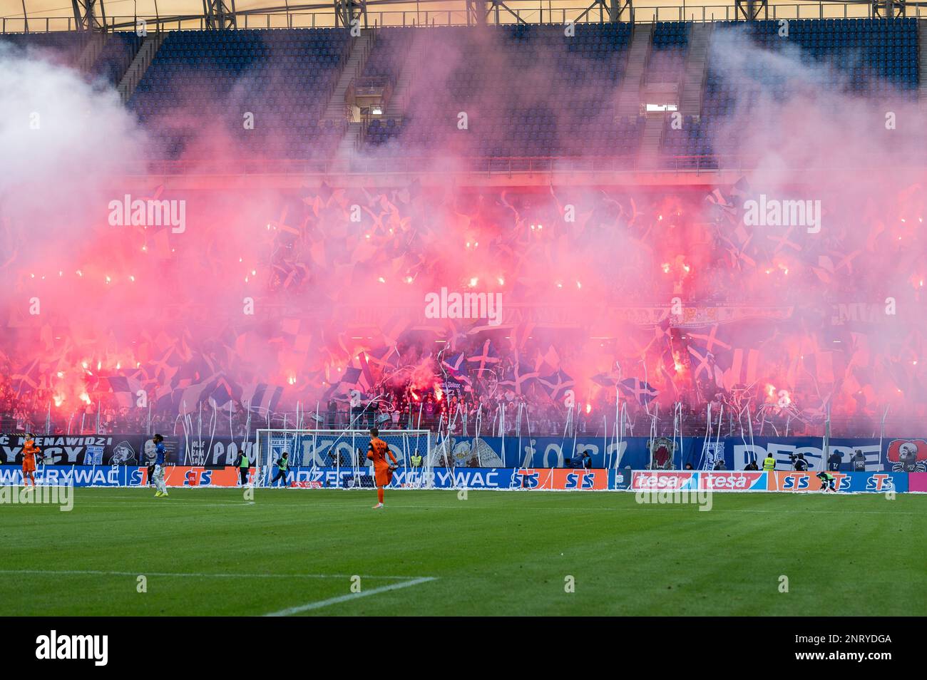POZNAN, POLONIA - 19 FEBBRAIO 2023: Partita di calcio PKO Ekstraklasa tra Lech Poznan vs KGHM Zaglebie Lubin 1:2. Sostenitori di Lech brucia fla Foto Stock