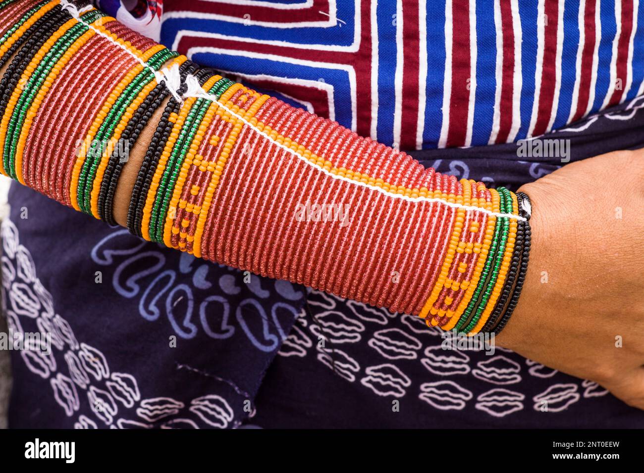 Lunghe e singole ciocche di perline avvolte intorno alle braccia e alle gambe delle donne Cuna di Panama che fanno motivi geometrici chiamati wini. I Cuna sono Ameri Foto Stock