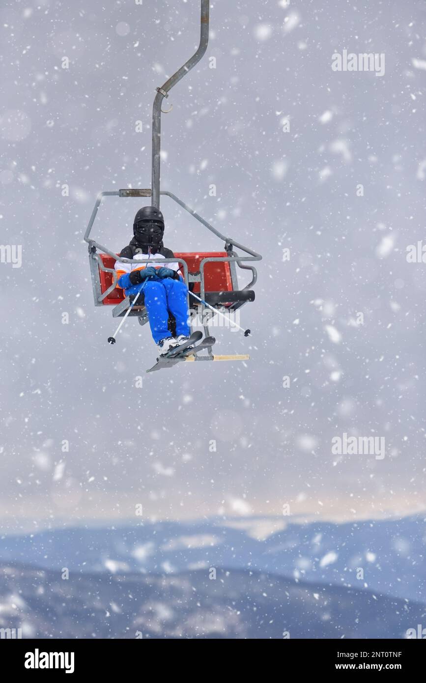 Un giovane sciatore che si diverta a sciare su un Teleski in una serena montagna in mezzo alla neve caduta Foto Stock